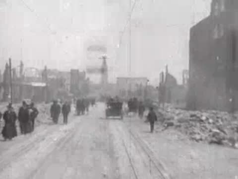Street view after San Francisco earthquake, pedestrians, debris piles, horse carriages.