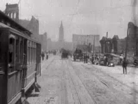 Passing a streetcar on the left as people walk down the ruined San Francisco street.
