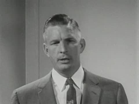 Man speaking close-up at podium in a studio setting