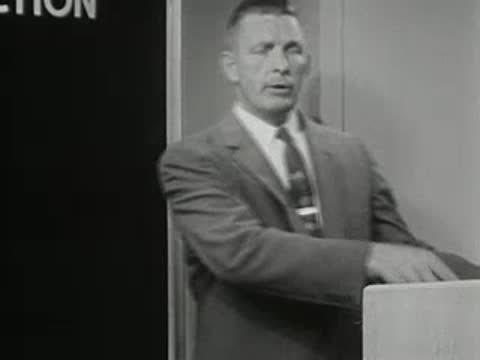 Man in suit speaks standing in front of a chart, 1950s instructional film