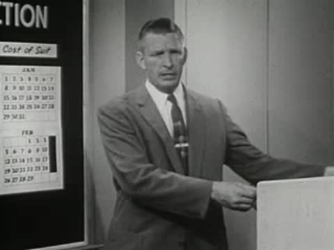 Man in suit holds up a sign, 1950s instructional film