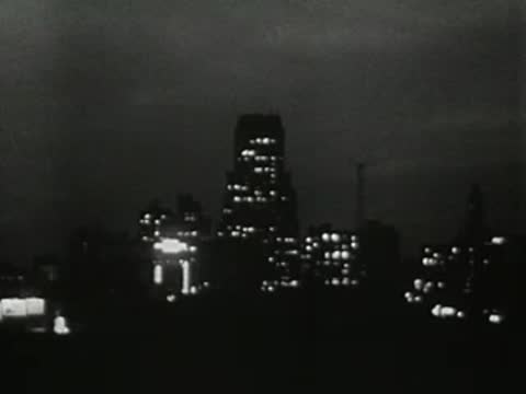City skyline at night with lit buildings, 1950s animation