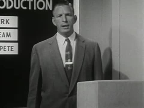 medium close-up of a man in suit speaking behind a podium