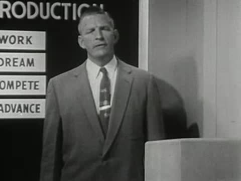 medium close-up of a man in a suit talking at a podium
