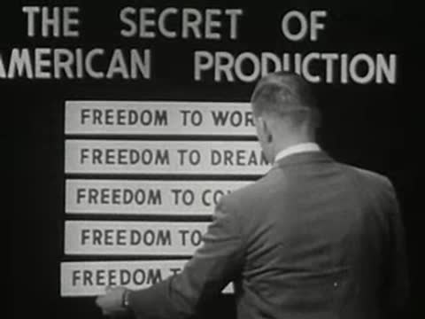 man in suit placing a text strip onto a board on set