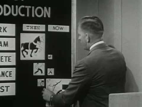 A speaker at a chalkboard places a graphic labeled with a horse illustration.
