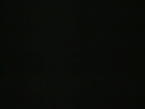 A very dark, nearly black screen shows the silhouette of a speaker.
