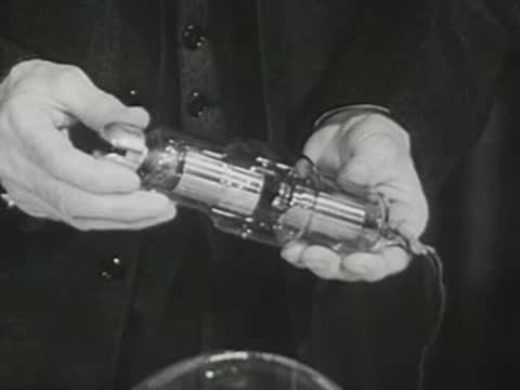 Presenter holding and adjusting a tubular glass device in his hands.