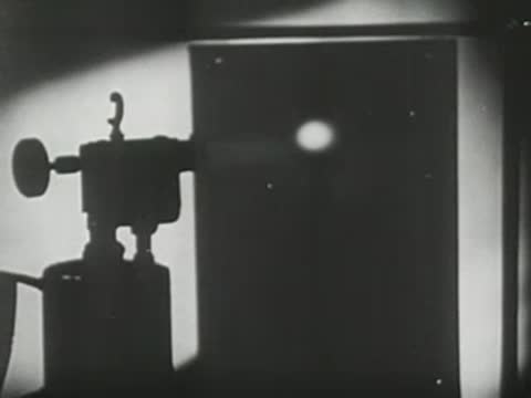 Setup in a dark laboratory showing an X-ray tube emitting light towards a screen.