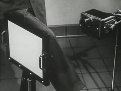 Industrial or laboratory machinery with protective clothing hanging over a panel.
