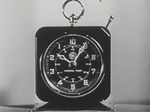 Man sitting cross-legged in front of a clock, then close-up of the clock.