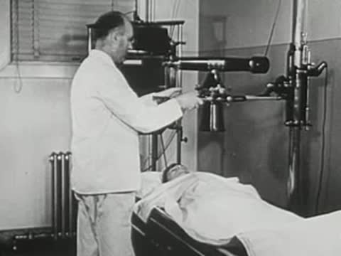 Doctor operating an advanced X-ray machine with a patient lying down.