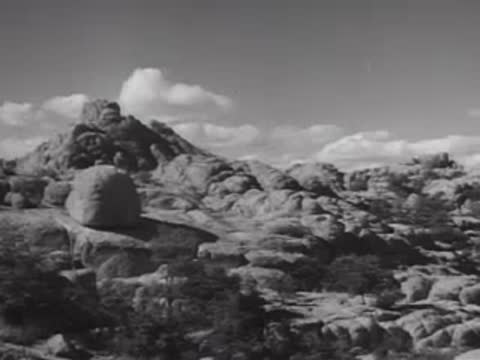 Scenic view of rocky hills and sparse landscape under a cloudy sky