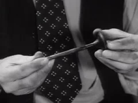 A man's hands using a dropper to handle liquid in a laboratory setting.