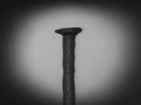 Close-up view of a metal nail being subjected to corrosion over time.