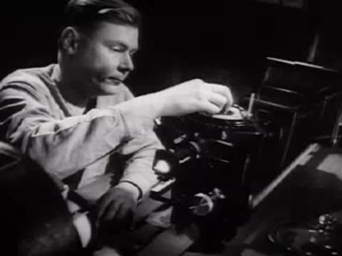 A researcher operating laboratory testing equipment in a dark room.