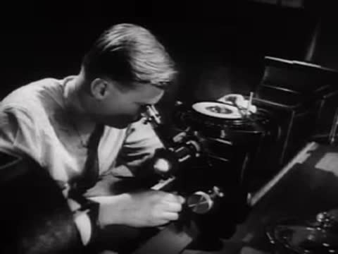 A researcher examining a sample through a microscope in a laboratory.