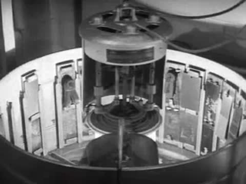 A rotary weathering machine operating with mounted metal panels in a laboratory.