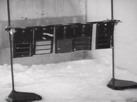 A rack of weathered metal panels standing outdoors in the snow.