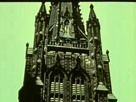 Low-angle shot of a gothic church steeple against a pale sky.
