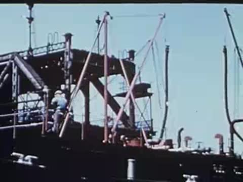 workers on a boat deck with crane rigging visible