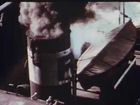 tugboat smokestack puffing smoke followed by a railroad signal light