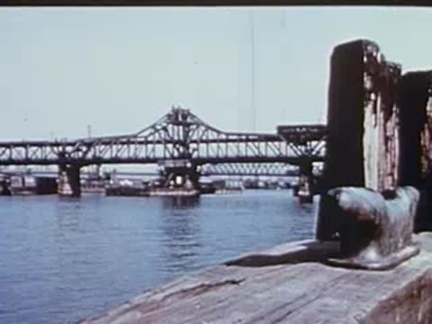 view of a bridge across the river from a wooden pier