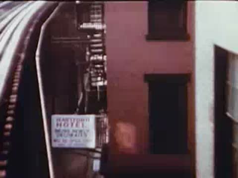 people sitting on apartment fire escapes on a brick building