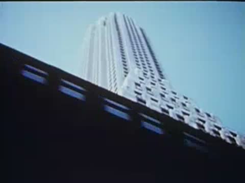 skyscraper viewed past the dark framework of the el train