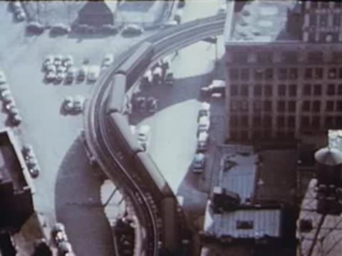 aerial view curving elevated train tracks, city buildings below