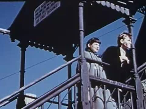 woman walking down outdoor station stairs against a blue sky