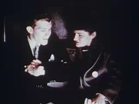man and woman sitting together inside a dimly lit vehicle