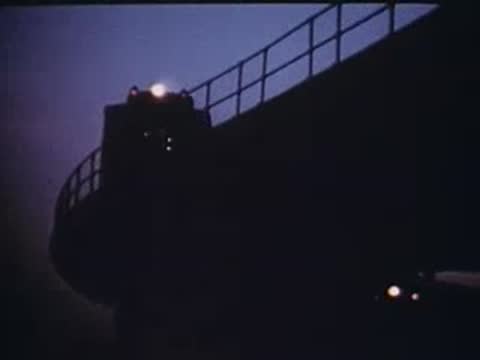 elevated train tracks curving against a dusky evening sky
