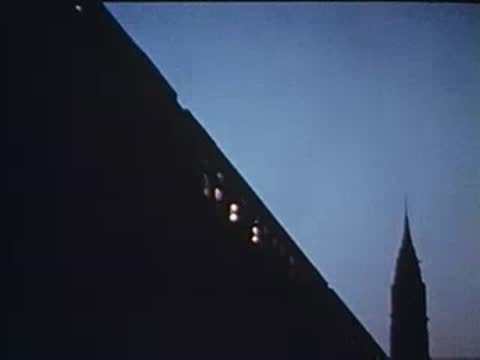angled view of a building facade and skyline at dusk