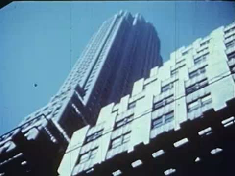 Low-angle view looking up a tall building with stepped architectural details.