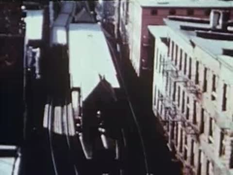 High-angle view looking down a narrow street flanked by brick buildings.