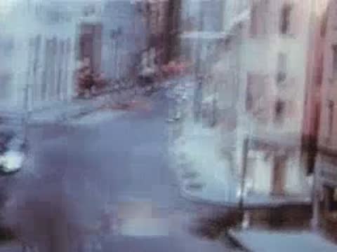 Blurred tracking shot from a moving vehicle looking down a city street.
