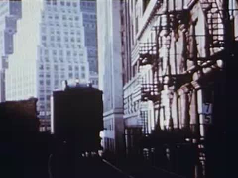 View from inside an elevated train looking down a city alleyway.