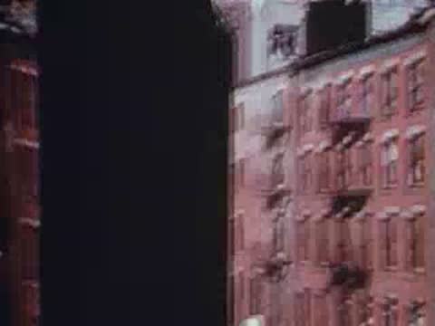 View from a train window passing by the red brick walls of buildings.