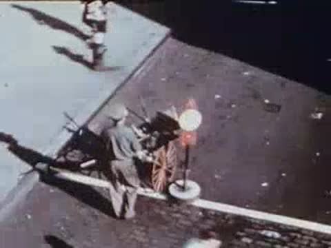 Man walking on city sidewalk past street sign, archival footage.