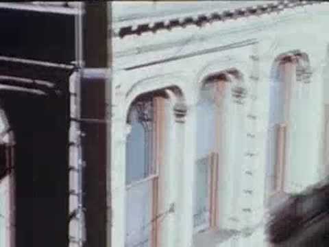 Exterior view of multi-story building facade with large windows, archival footage.