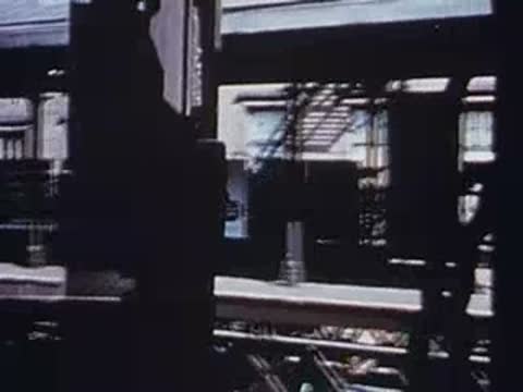 View from moving train passing elevated railway station platform, archival footage.