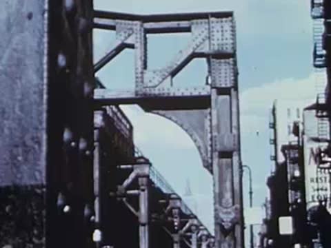 Heavy steel support structure of elevated railway against blue sky, archival footage.