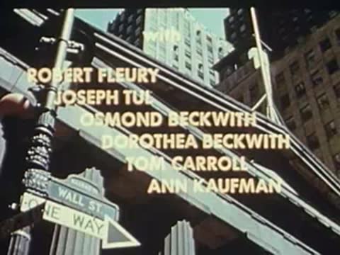 Looking up at a street sign reading Wall St, with credits superimposed.