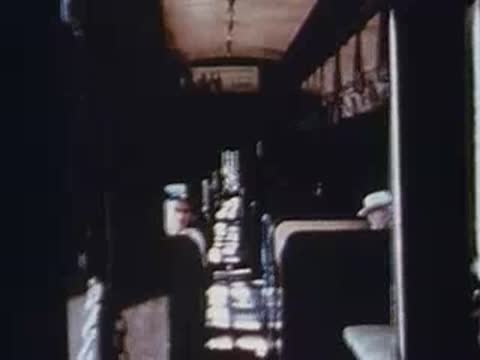 elderly man sitting inside moving train car, interior view