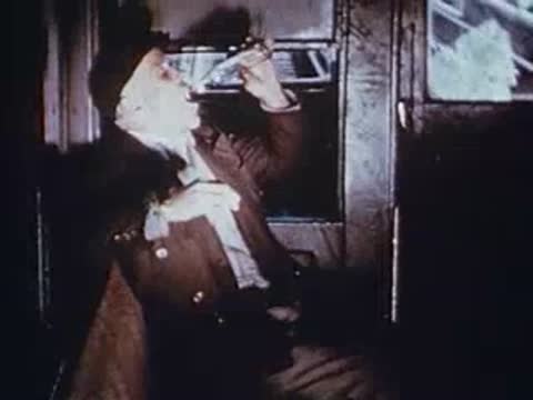 man sitting inside train drinking from small bottle