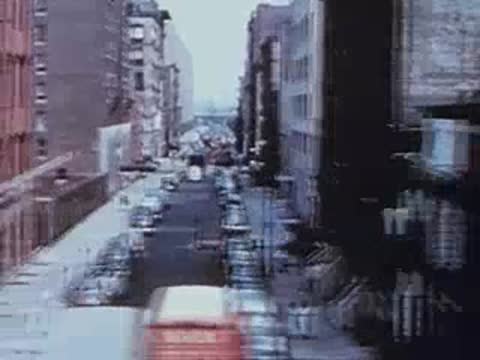 city street with parked cars viewed from elevated train