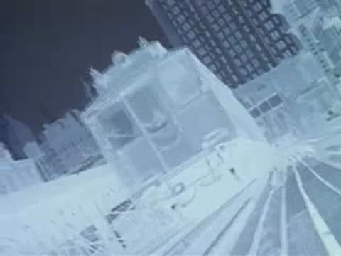 negative image of train tracks and buildings from train