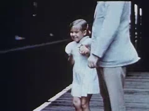 Little girl and man waiting on an elevated station platform.