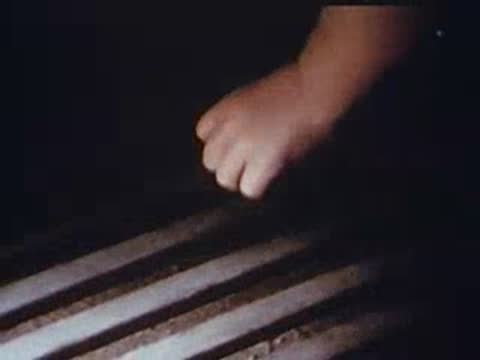 Close-up of someone tapping fingers on wooden slats.